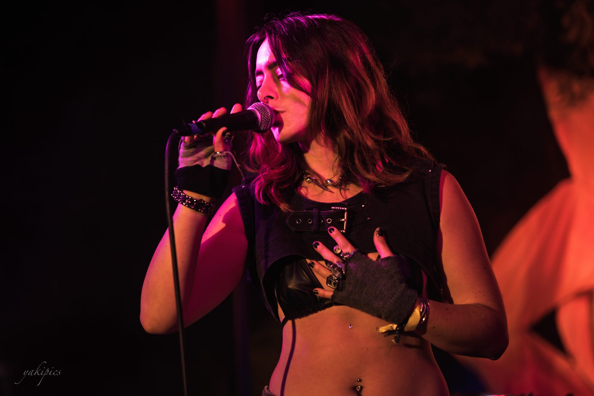 Singer performing in deep red stage light.
