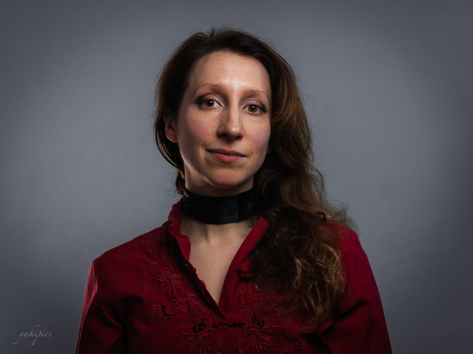 Moody studio portrait of a woman wearing deep red.